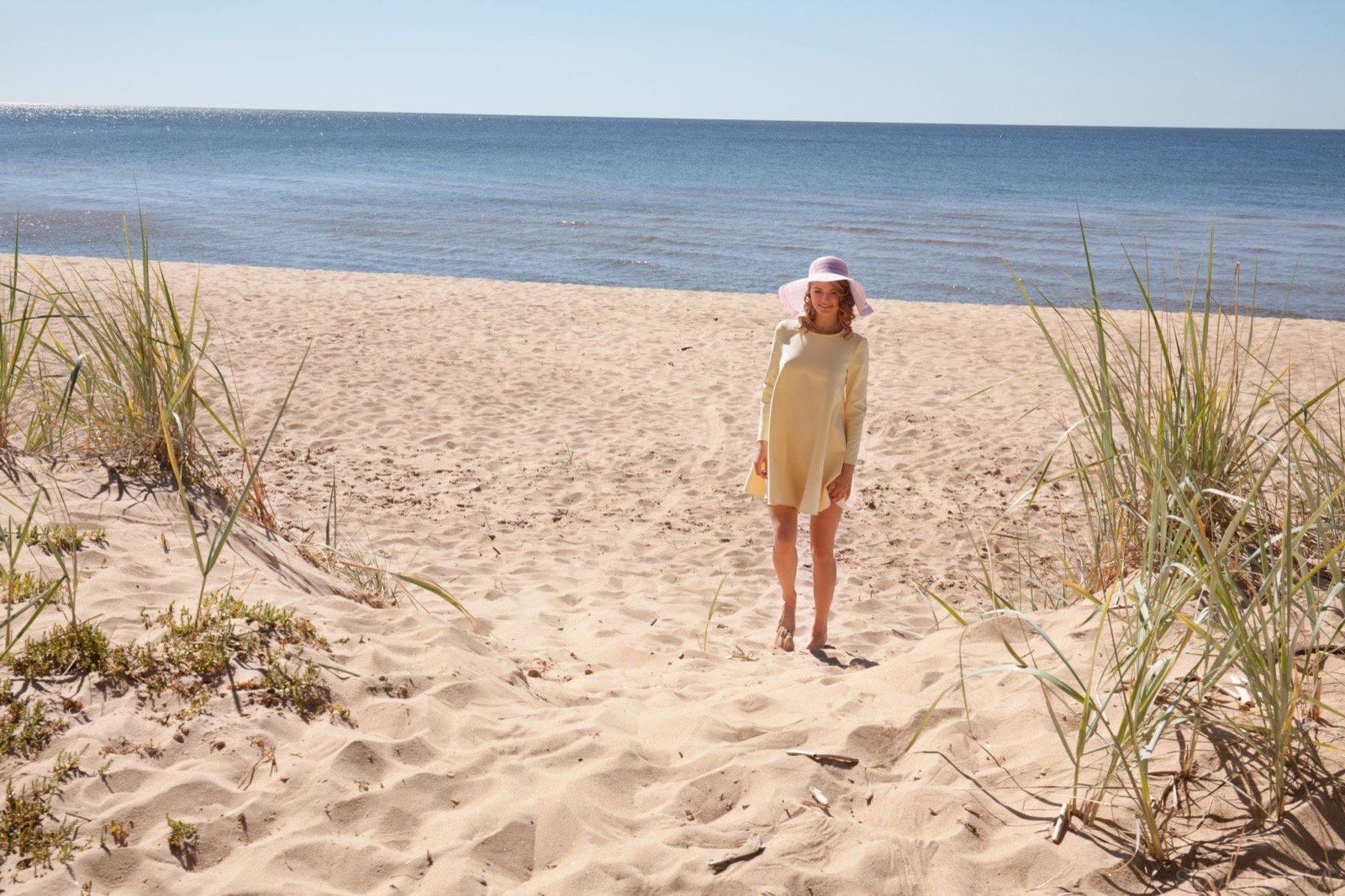 Очаровательная девка в шляпке оголяет попу на пляже
